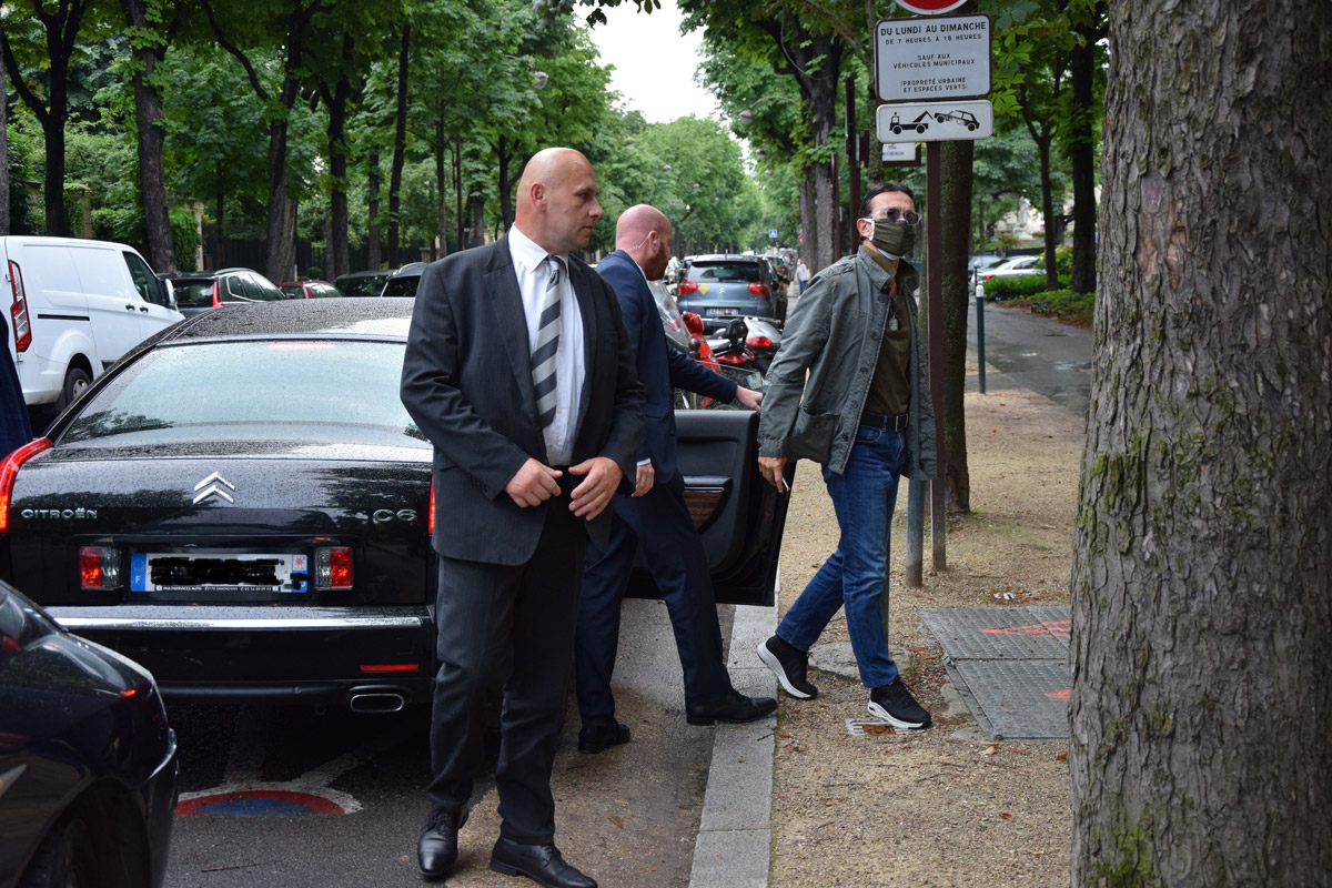 Deux agents de protection escortant leur client, tout juste sorti de la voiture.