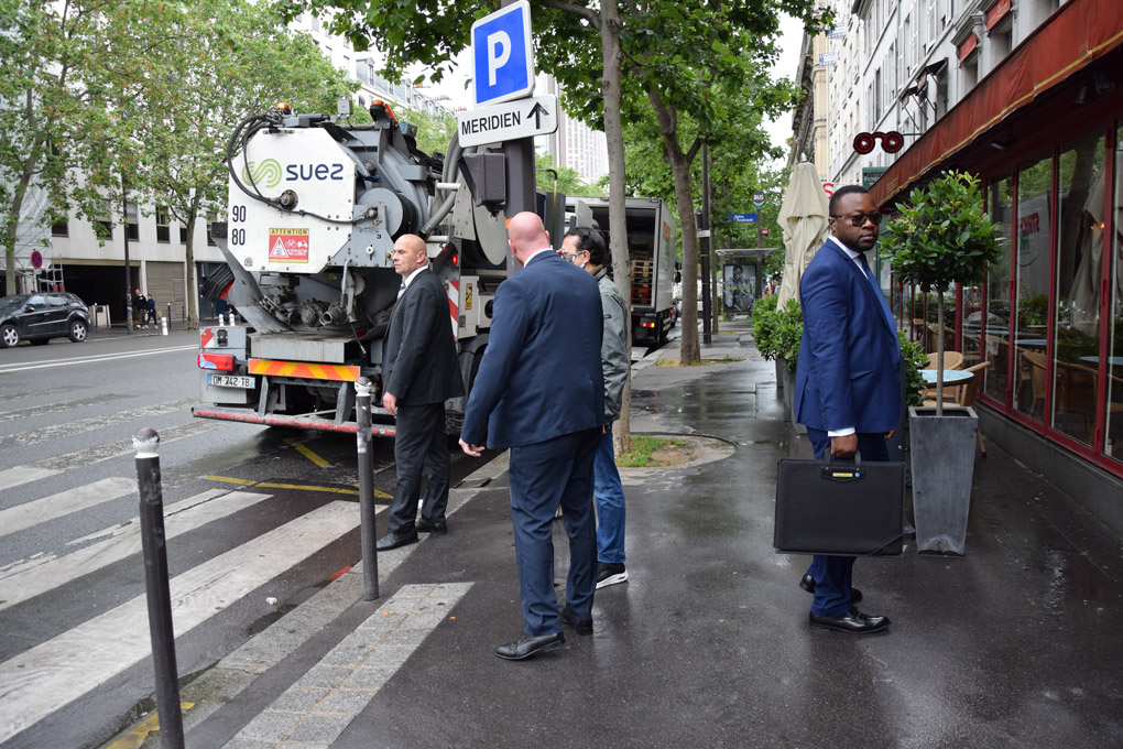 Les agents de protection rapprochée accompagnent leur client avant de traverser la rue.